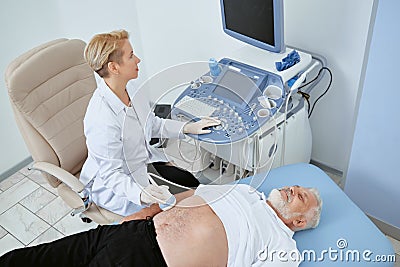 Doctor observing man with modern med device. Stock Photo