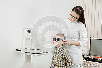 Doctor ophthalmologist checks child vision color blindness. Stock Photo