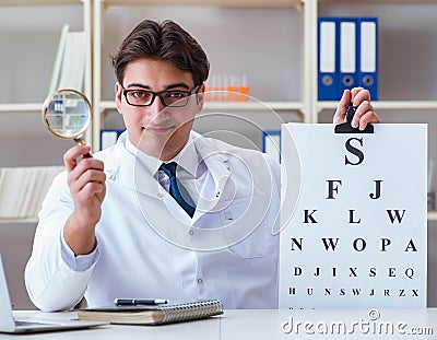 The doctor optician with letter chart conducting an eye test che Stock Photo