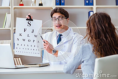 The doctor optician with letter chart conducting an eye test check Stock Photo