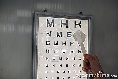 Doctor optician with letter chart for eye vision test check Stock Photo