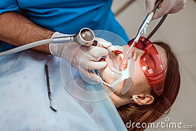 Doctor orthodontist performs a procedure for cleaning teeth Stock Photo