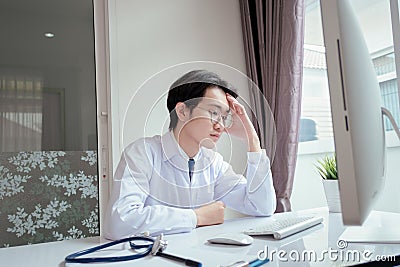 Doctor overworked with computer on desk clinic health care for pateint technology help support Stock Photo