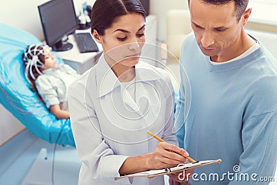 Doctor and parent talking over diagnosis of little girl Stock Photo