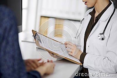 Doctor and patient discussing current health examination while sitting in clinic. Perfect medical service in hospital Stock Photo