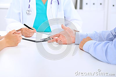 Doctor and patient are discussing something, just hands at the table Stock Photo