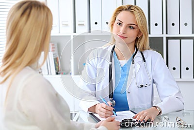 Doctor and patient discussing something while sitting at the table . Medicine and health care concept Stock Photo