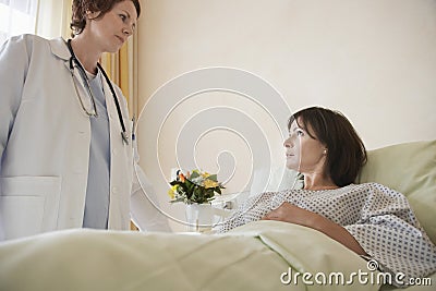 Doctor By Patient In Hospital Bed Stock Photo