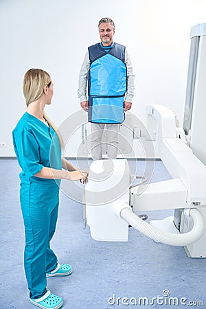 Doctor and patient in protective suit preparing for knee x-ray Stock Photo