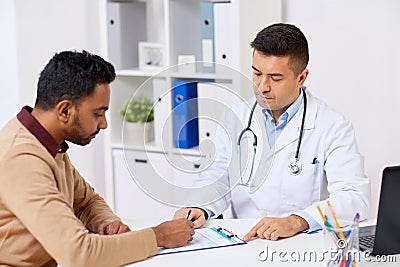 Doctor and patient signing document at clinic Stock Photo