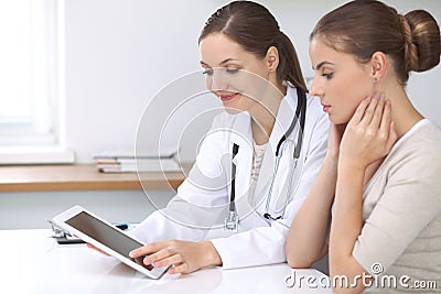 Doctor and patient sitting at the desk. The physician or therapist makes a diagnosis. Health care, medicine and patie Stock Photo