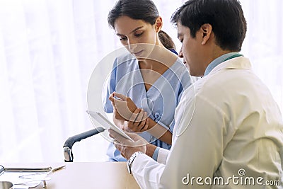 Doctor with pen and stethoscope sitting in office while talking about problem health patient woman fell friendly Stock Photo