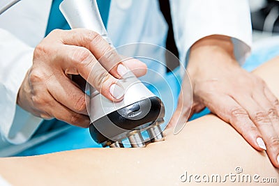 Doctor performing a radiofrequency treatment on a female patient leg Stock Photo