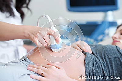 Doctor performing ultrasound scanning for her pregnant patient Stock Photo