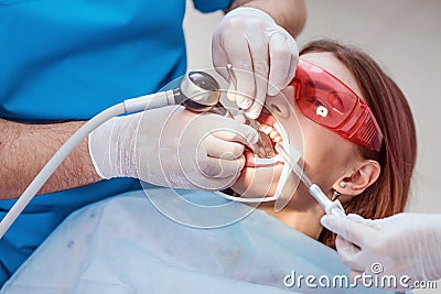 Doctor orthodontist performs a procedure for cleaning teeth Stock Photo