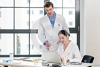Doctor and pharmacist checking information on a laptop in a hospital Stock Photo