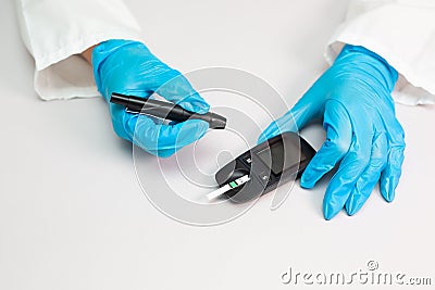 Doctor piercing patients finger with lancet in clinic closeup. Blood glucose control concept Stock Photo