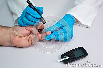 Doctor piercing patients finger with lancet in clinic closeup. Blood glucose control concept Stock Photo