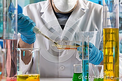 Doctor pipetting sample in cell tissue culture bottle in the research lab Stock Photo