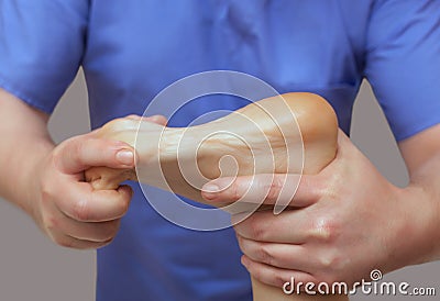 The doctor-podiatrist does an examination and massage of the patient`s foot Stock Photo