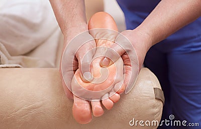 The doctor-podiatrist does an examination and massage of the patient`s foot Stock Photo