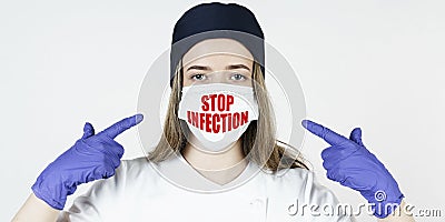 The doctor points his fingers at the mask with the inscription - STOP INFECTION Stock Photo