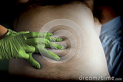 Doctor preparing abdominal palpation in a hospital, conceptual image Stock Photo