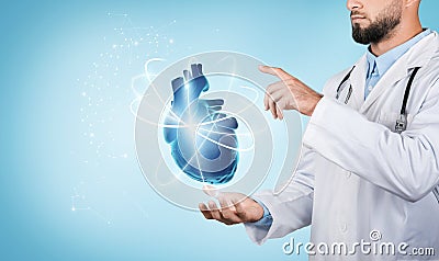 Doctor presenting holographic heart, blue backdrop Stock Photo