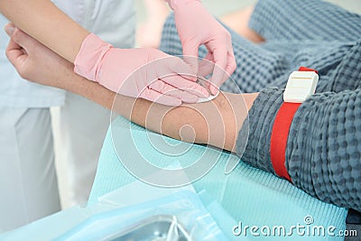 Doctor in protective gloves takes blood from a patient Stock Photo