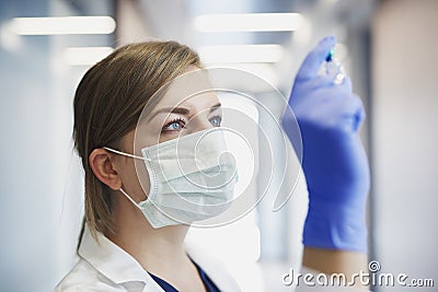 Doctor in protective mask with an ampule in hand Stock Photo