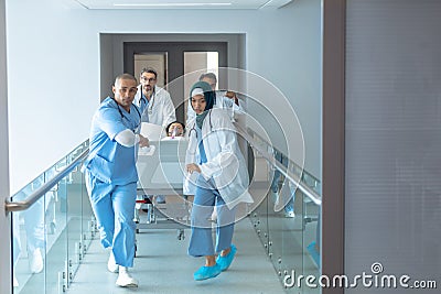 Doctor pushing emergency stretcher bed in corridor at hospital Stock Photo