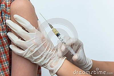 Doctor puts a syringe in arm Stock Photo