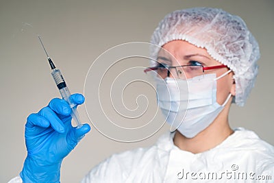 The doctor puts the vaccine to the patient from the virus. Protection from the epidemic. On the face of a protective mask. Glasses Stock Photo