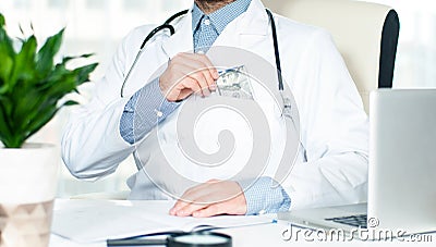 Doctor putting money in his pocket Stock Photo