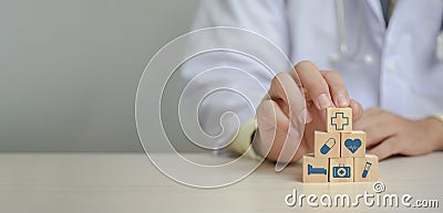 Doctor putting and stacking wooden block cube icon symbol medical health care on table panorama background concept Stock Photo