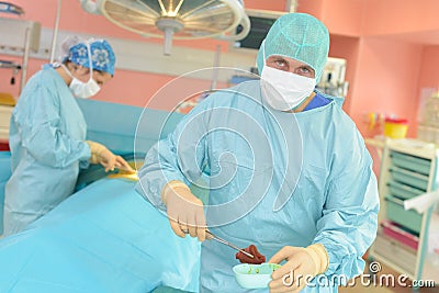 Doctor removing organ from patient Stock Photo