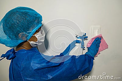 The doctor in rubber gloves disinfects switch with disinfectant and napkins. Convalescence Stock Photo