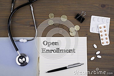 Doctor's desk with notebook and text - Open Enrollment Stock Photo