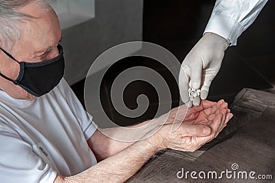 Doctor`s hand gives an old patient a pill. Gerontology service, nursing home. Unrecognizable people, part of the body Stock Photo