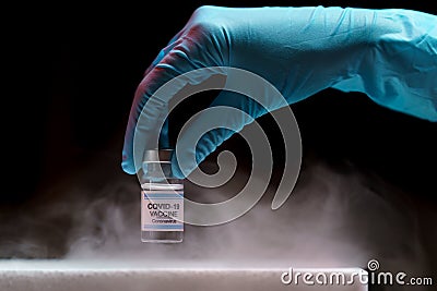 Doctor`s hand holding bottle vaccine Covid-19 from storage box. Medication treatment concept Stock Photo