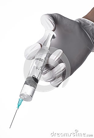 Doctor's hand holding a syringe, white-gloved hand, a large syringe, medical issue, the doctor makes an injection Stock Photo