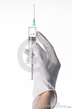 Doctor's hand holding a syringe, white-gloved hand, a large syringe, medical issue, the doctor makes an injection Stock Photo