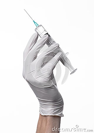 Doctor's hand holding a syringe, white-gloved hand, a large syringe, medical issue, the doctor makes an injection Stock Photo