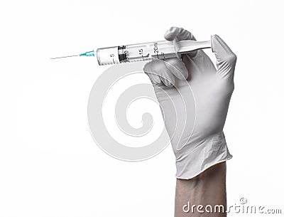 Doctor's hand holding a syringe, white-gloved hand, a large syringe, medical issue, the doctor makes an injection Stock Photo