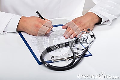 Doctor`s hand signing document Stock Photo
