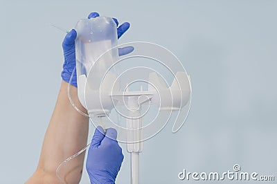 Doctor`s hands and infusion drip in hospital on blurred background Stock Photo