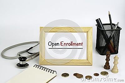 Doctor's working table with the frame and the text - Open Enroll Stock Photo