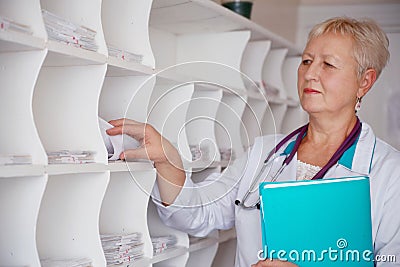 Doctor searching medical chart in clinic Stock Photo