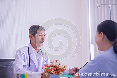 Doctor Senior Asian man and patient woman. Doctors giving a consultation Explain the medical to patient Stock Photo