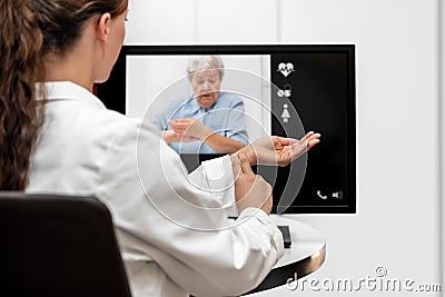 Doctor and senior woman taking the pulse, telemedicine and video Stock Photo